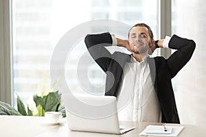 Satisfied businessman relaxing at workplace