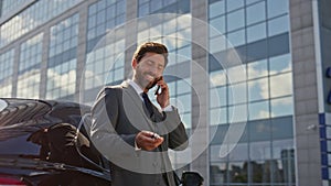 Satisfied businessman talking smartphone playing with car keys closeup zoom in.