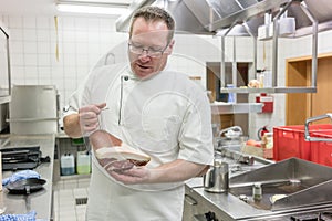 Satisfied chef inspecting delicious smoked ham in a piece