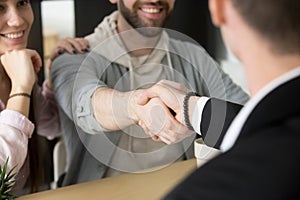 Satisfied couple handshaking realtor closing successful deal photo