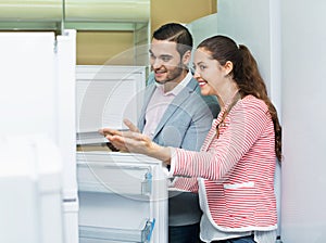 Satisfied couple looking at large fridges