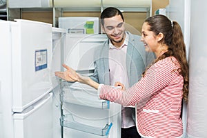 Satisfied couple looking at large fridges