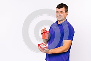 A satisfied deaf man received a hearing aid in a red gift box as a present. White background and empty sidewall space.