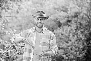 Satisfied farmer hold garden rake and flower pot. muscular ranch man in cowboy hat. farming and agriculture. Garden