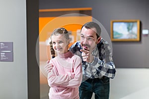 satisfied father and daughter exploring expositions in museum