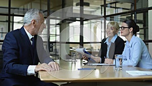 Satisfied female manager shaking aged applicant hand, office interview, work