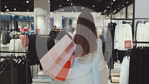 Satisfied Female Shopper Walking with Bags in Clothing Store