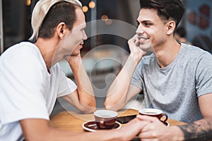 Satisfied guy speaking with comrade at desk