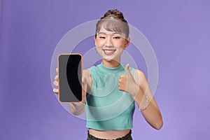 Satisfied happy asian girl show thumbs-up as demonstrate mobile phone screen application