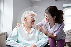 Satisfied and happy senior woman patient with nurse photo