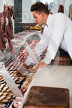 Satisfied man cook cutting meat in butcher market