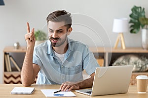 Satisfied man with raised hand thinking about good creative idea