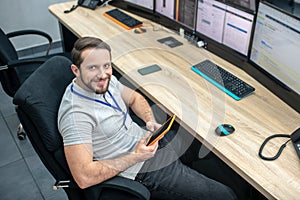 Satisfied man with tablet at workplace during break