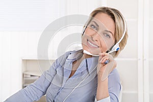 Satisfied mature businesswoman with headphone at office.