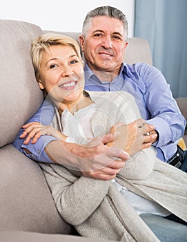 satisfied mature married couple in house are warmly reconciled after quarrel