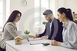 Satisfied millennial couple clients signing real estate contract agreement