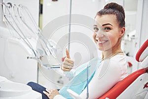 Satisfied patient showing her perfect smile after treatment in a dentist clinic