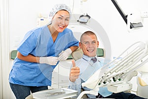 Satisfied patient visiting dentist giving thumbs up