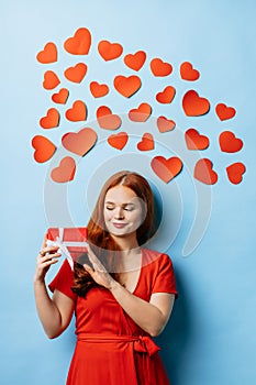 Satisfied redhaired woman with gift isolated