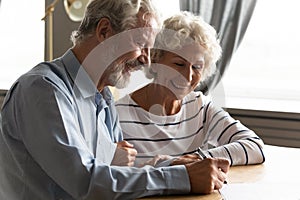 Satisfied senior couple signing agreement buying medical health insurance