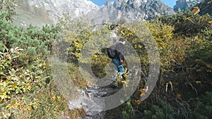 Satisfied traveler man climbing along a hiking route to the top of mountain, Alps, Austria