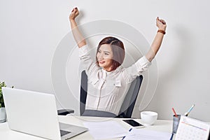 Satisfied woman relaxing with hands behind her head. Happy smiling employee after finish work, reading good news, break at work,