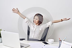 Satisfied woman relaxing with hands behind her head. Happy smiling employee after finish work, reading good news, break at work,