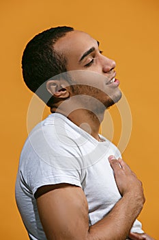 Satisfy Afro-American man is smiling against orange background