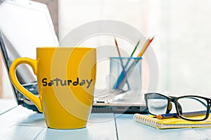 Saturday on morning coffee cup at businessman workplace or office background photo