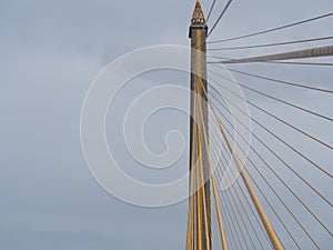 Saturn, yellow-brown bridge, golden yellow slink and turquoise sky, white-gray clouds.