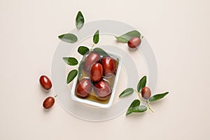 Sauce boat with jojoba oil and seeds on light background