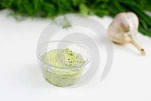 Sauce with herbs in a plastic gravy bowl