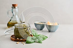 Sauce pesto in glass jar with fresh basil