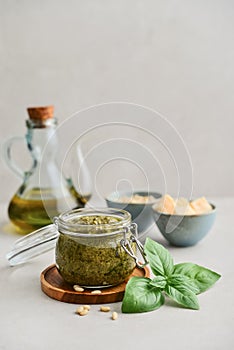 Sauce pesto in glass jar with fresh basil