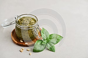 Sauce pesto in glass jar with fresh basil