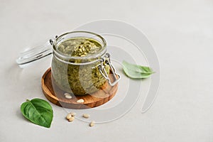 Sauce pesto in glass jar with fresh basil