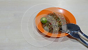 A sauce plate with chili soy sauce condiment, with a calamansi at the side