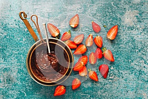 Saucepan of melted chocolate and strawberry pieces