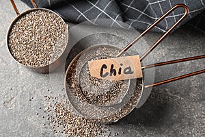 Saucepans with chia seeds on grey, flat lay