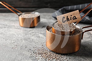 Saucepans with chia seeds on grey table