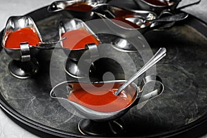 Saucepans with meat sauce are on a tray