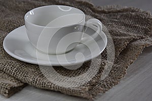 saucer and empty white tea cup on canvas