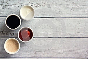 Sauces ketchup, mustard, mayonnaise, sour cream, soy sauce in clay bowls on wooden white background