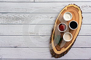 Sauces ketchup, mustard, mayonnaise, sour cream, soy sauce in clay bowls on wooden white background