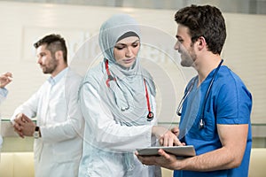 Saudi arab doctors working with a tablet.