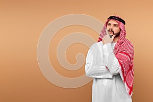 The Saudi Arab man is thinking about something. Dishdasha, kandora, thobe, islam. Copy space