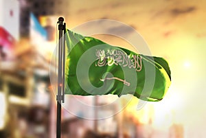 Saudi Arabia Flag Against City Blurred Background At Sunrise Backlight photo