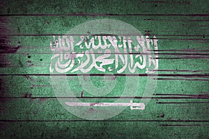 Saudi Arabia national flag on wooden rustic background.