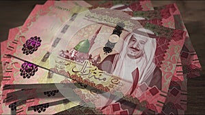 Saudi Arabia Rial 100 money banknotes falling on the table
