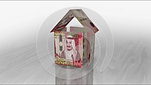 Saudi Arabia Rial 100 SAR money banknotes paper house on the table